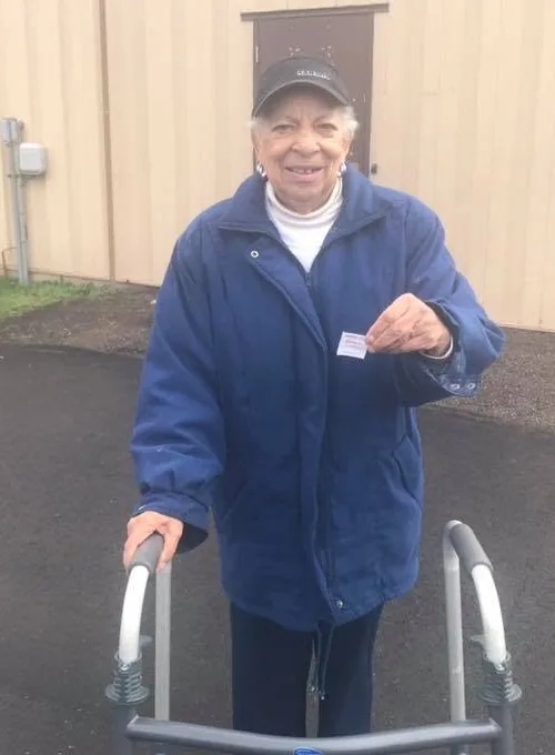 Elaine smiling outdoors with her walker
